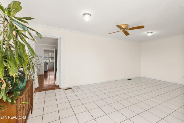 spare room with ceiling fan, ornamental molding, and light tile patterned floors