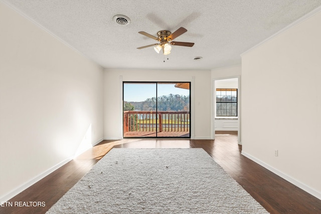 empty room featuring a textured ceiling, ceiling fan, and dark wood-type flooring