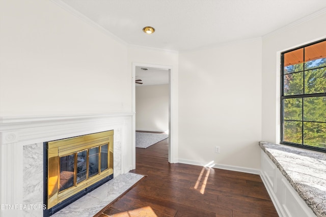 living room with a premium fireplace, plenty of natural light, crown molding, and dark wood-type flooring