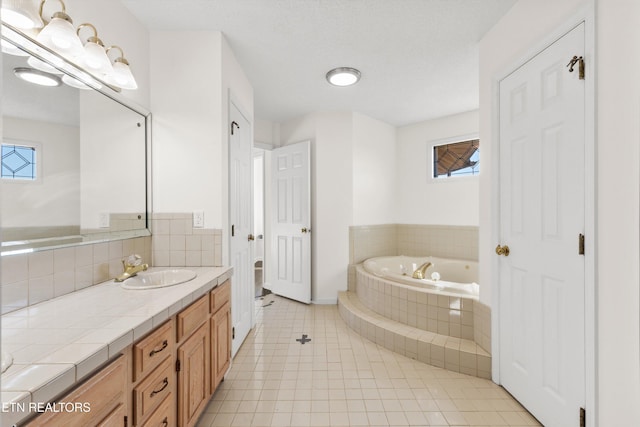 bathroom featuring vanity, tile patterned flooring, and tiled bath