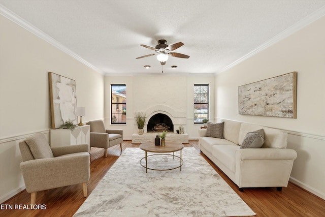 living room featuring ornamental molding, ceiling fan, and wood-type flooring