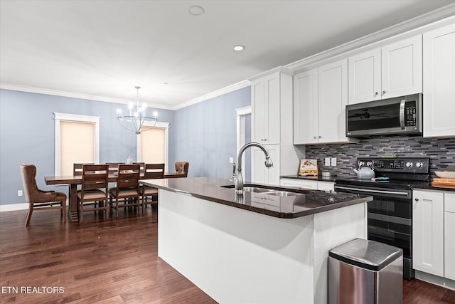 kitchen featuring sink, dark wood-type flooring, decorative light fixtures, a center island with sink, and appliances with stainless steel finishes