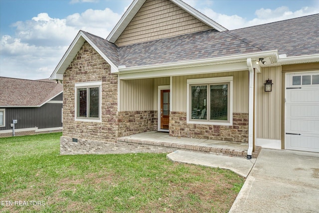 entrance to property featuring a lawn, covered porch, and a garage