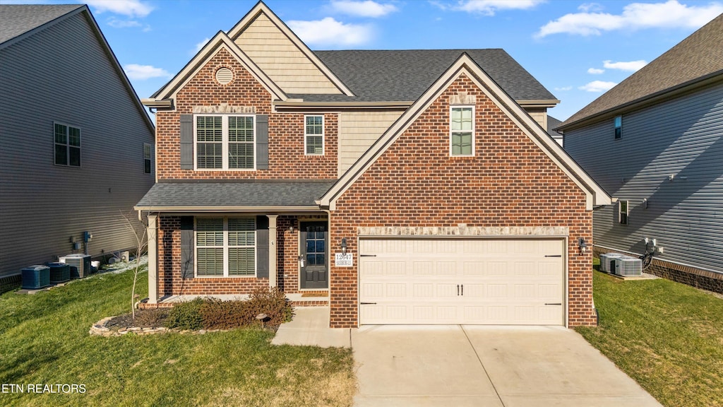 front facade with a garage, cooling unit, and a front lawn