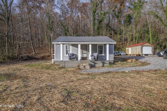 view of front facade featuring a porch, a shed, and a garage