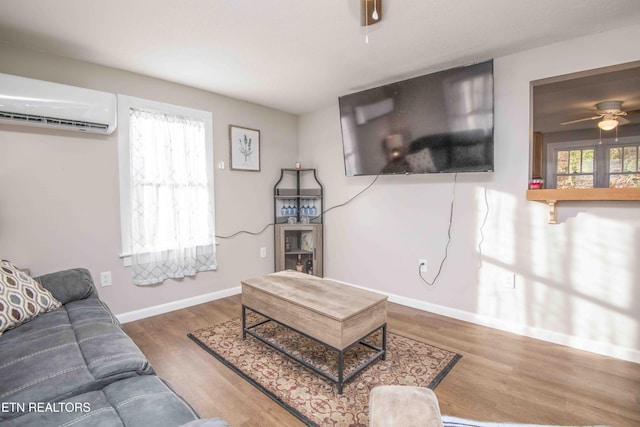 living room with a wall mounted AC, ceiling fan, and hardwood / wood-style floors