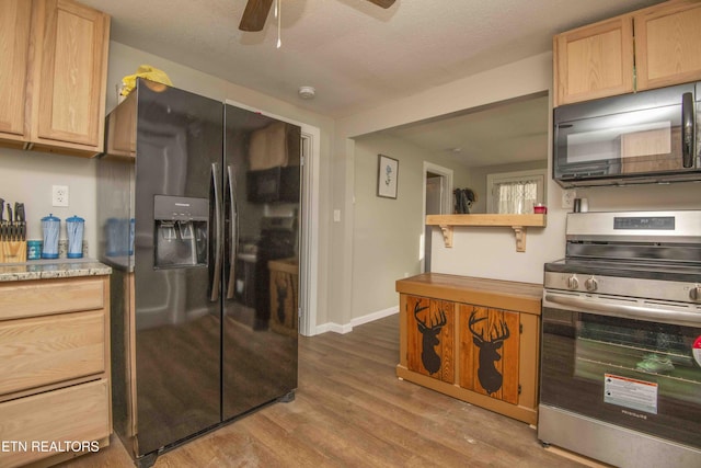 kitchen featuring light wood-type flooring, a textured ceiling, ceiling fan, black appliances, and light brown cabinets