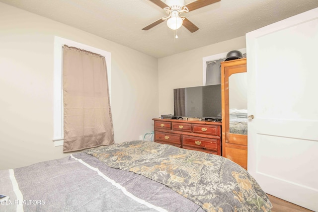 bedroom with ceiling fan, a textured ceiling, and hardwood / wood-style flooring