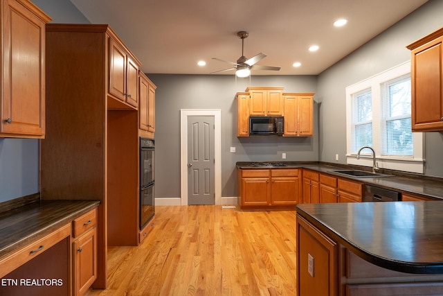 kitchen featuring sink, black appliances, light hardwood / wood-style floors, and ceiling fan