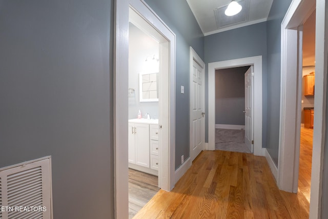 hallway with sink and light hardwood / wood-style flooring