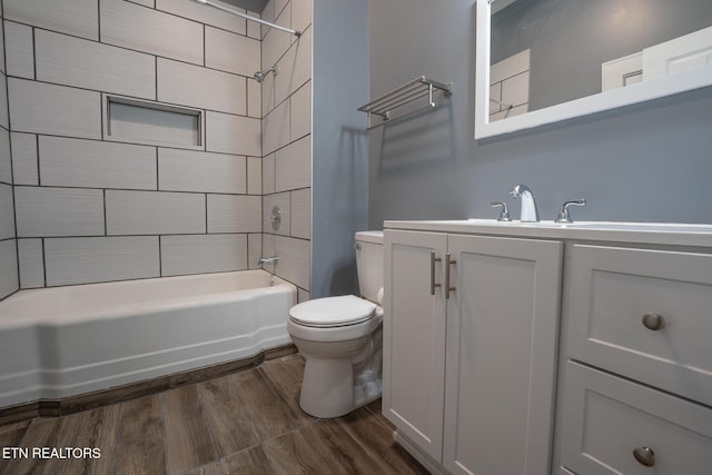 full bathroom with vanity, toilet, tiled shower / bath combo, and hardwood / wood-style floors