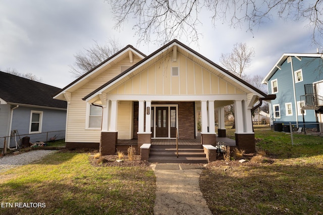 bungalow-style house featuring a front yard and covered porch