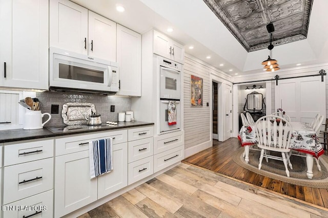 206 E Cedar Street 206E Cedar St E Cedar St, Livingston, TN 38570 - kitchen featuring a raised ceiling, a barn door, white appliances, white cabinets, and light wood-type flooring