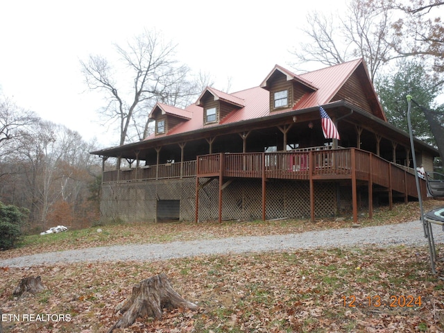 back of property featuring a trampoline and a deck