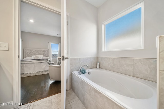 bathroom with tiled bath and tile patterned flooring