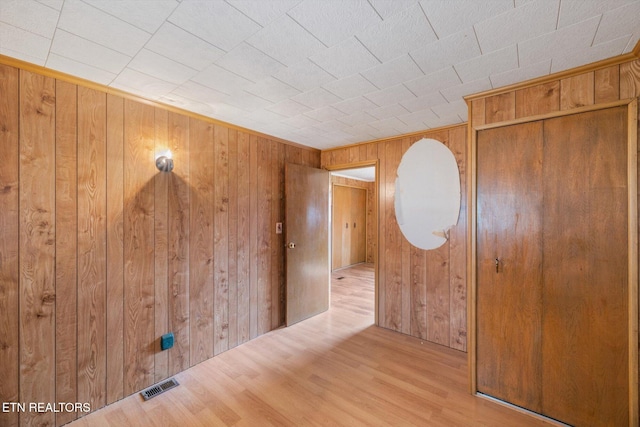 interior space featuring wood walls and light wood-type flooring