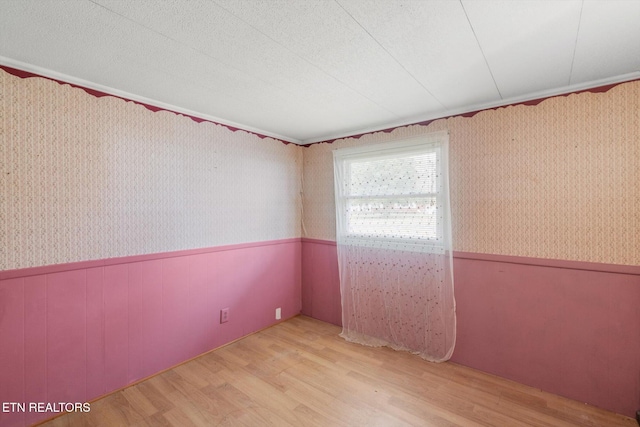 spare room with light hardwood / wood-style floors and a textured ceiling