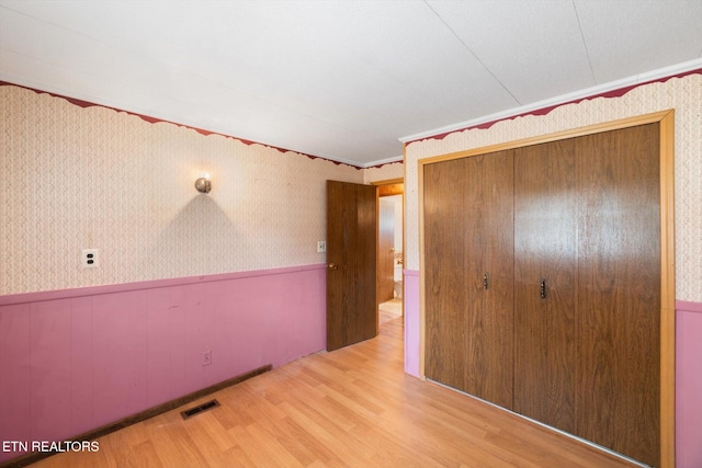 unfurnished bedroom with a closet and light hardwood / wood-style flooring