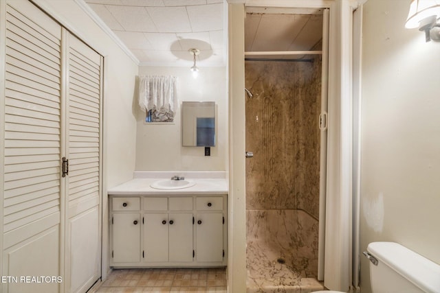 bathroom with vanity, toilet, crown molding, and walk in shower