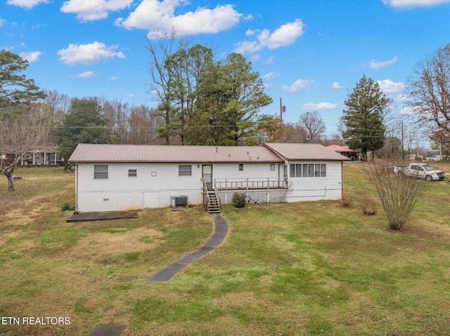 back of house with cooling unit, a deck, and a yard