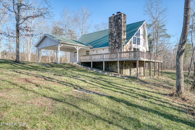 rear view of house featuring a lawn and a deck