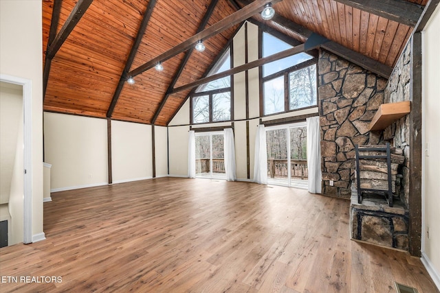 unfurnished living room featuring wooden ceiling, high vaulted ceiling, hardwood / wood-style flooring, a fireplace, and beamed ceiling