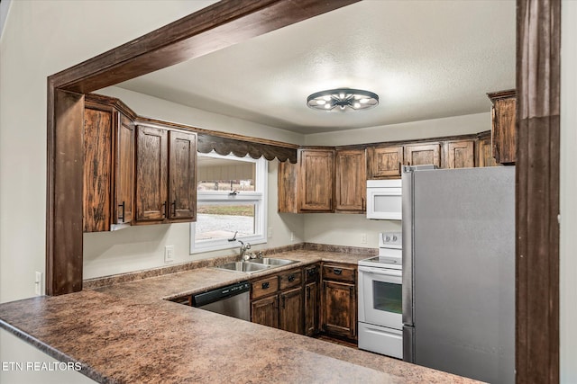 kitchen featuring a textured ceiling, dark brown cabinetry, sink, and appliances with stainless steel finishes