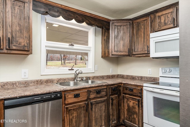 kitchen featuring dark brown cabinetry, white appliances, and sink