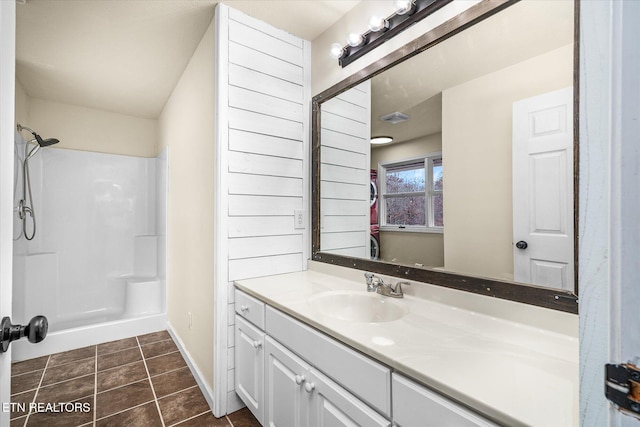 bathroom with tile patterned flooring, vanity, and walk in shower