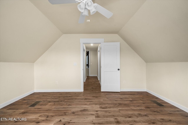 additional living space with dark hardwood / wood-style flooring, vaulted ceiling, and ceiling fan