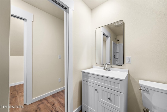 bathroom featuring toilet, vanity, and hardwood / wood-style flooring