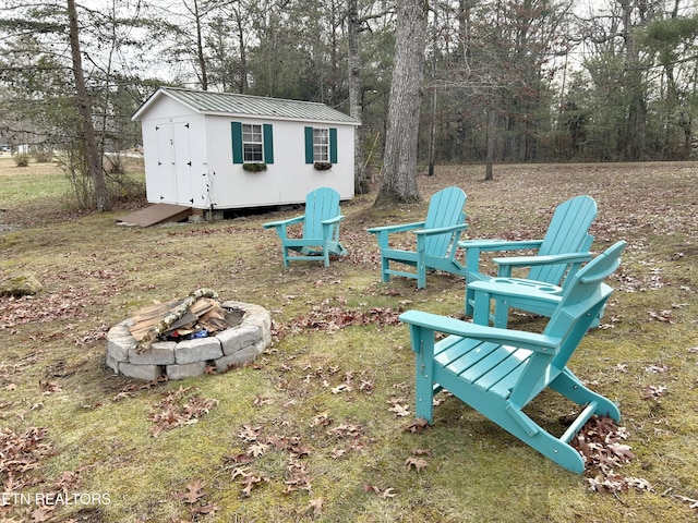 view of yard featuring a fire pit and an outdoor structure