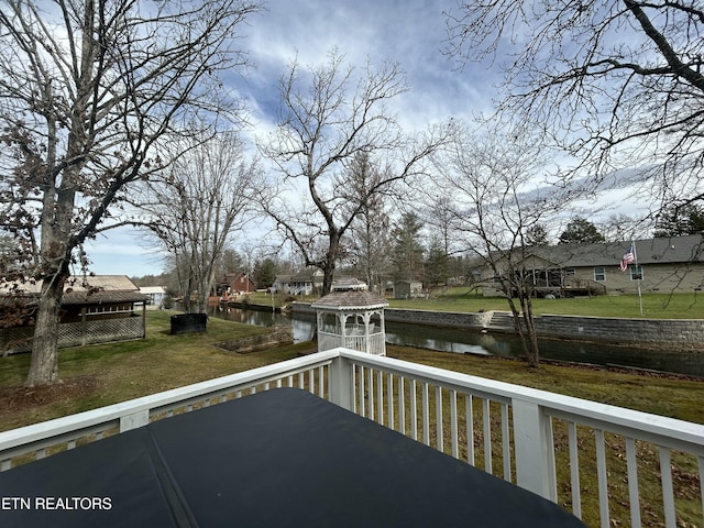 deck with a yard and a water view