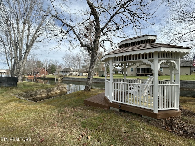 dock area featuring a deck with water view, a gazebo, and a yard