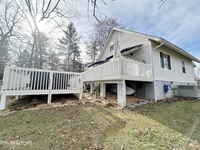 view of side of home with a lawn, cooling unit, and a deck