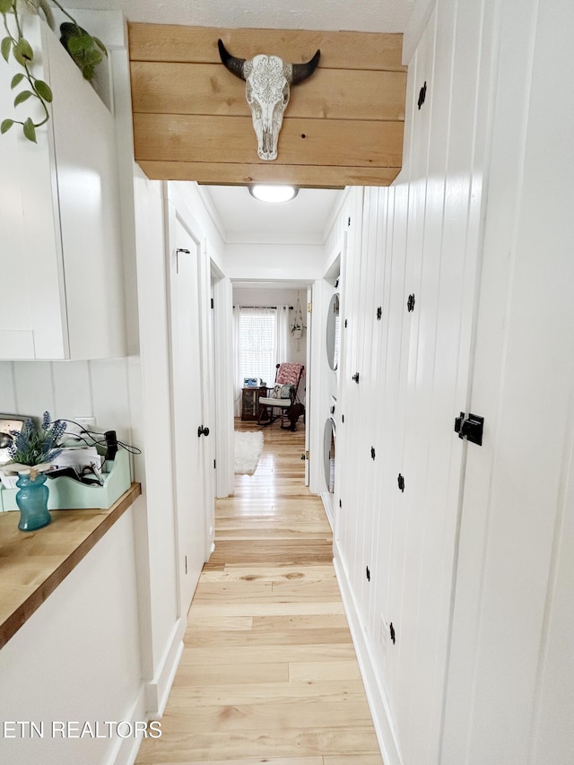 hallway with crown molding and light hardwood / wood-style floors