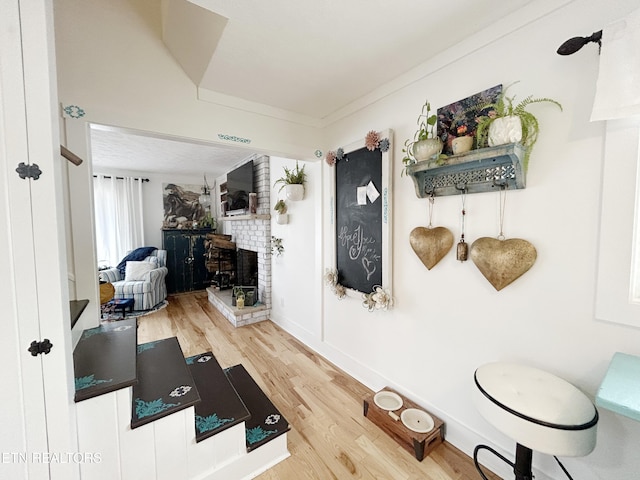 interior space with hardwood / wood-style floors, a fireplace, and crown molding