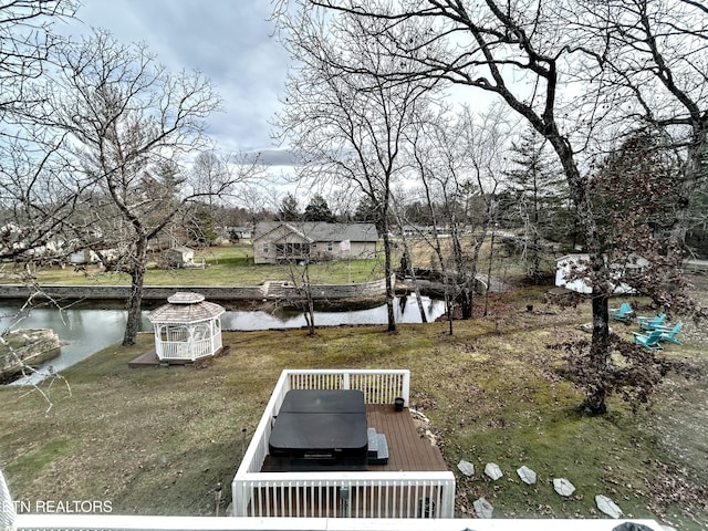 exterior space featuring a deck with water view and an outdoor structure