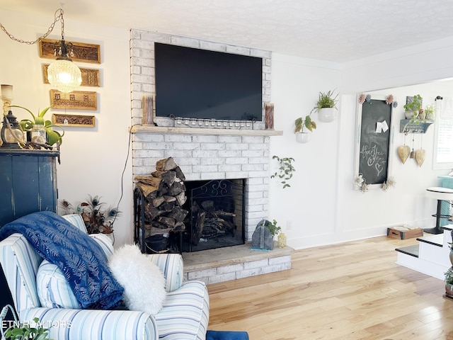 living room featuring a fireplace, a textured ceiling, and hardwood / wood-style flooring