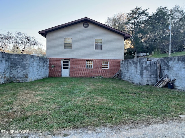 back of property featuring a lawn