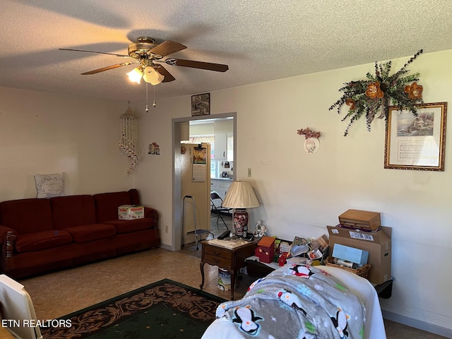 living room featuring ceiling fan and a textured ceiling