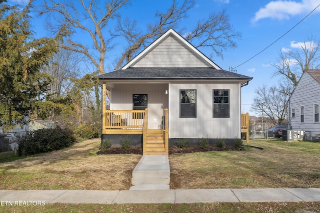 bungalow-style home featuring covered porch and a front lawn