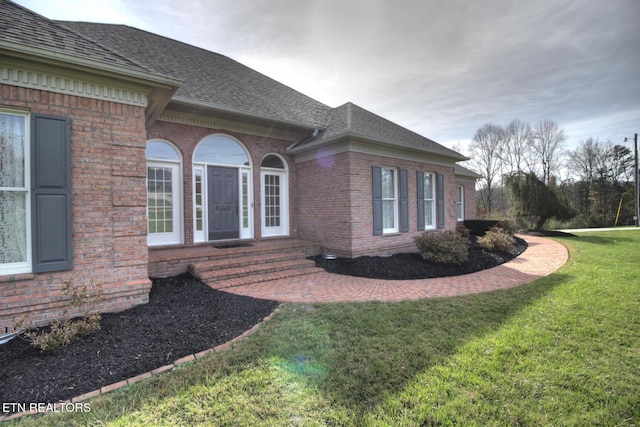 view of exterior entry with a lawn