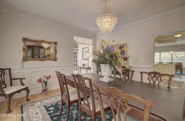 dining area featuring a chandelier, wood-type flooring, and ornamental molding