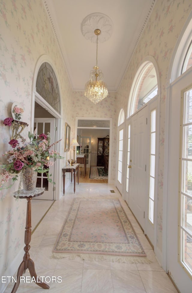 entrance foyer featuring a notable chandelier and ornamental molding