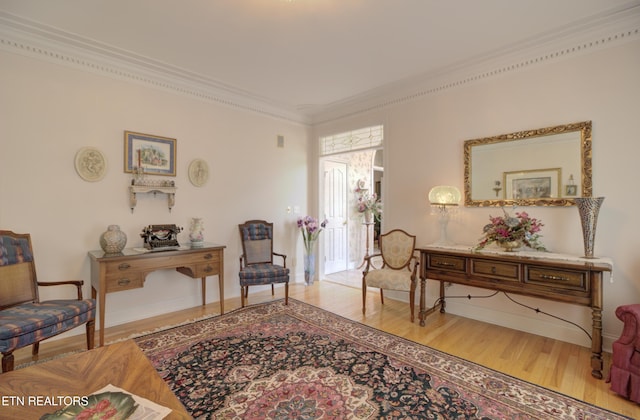 living area featuring hardwood / wood-style flooring and crown molding