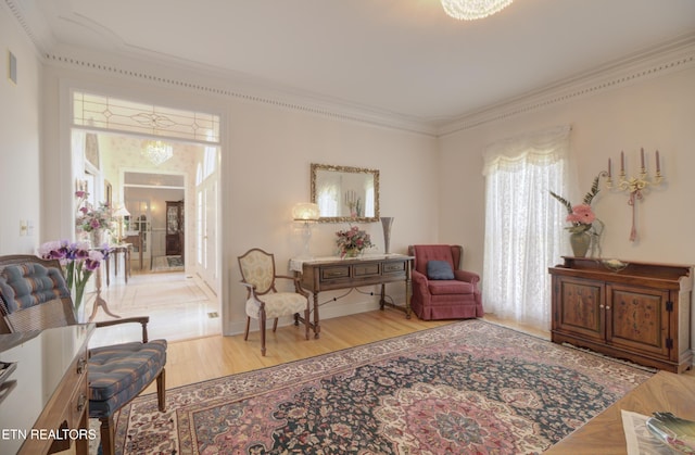 sitting room featuring crown molding and light hardwood / wood-style flooring