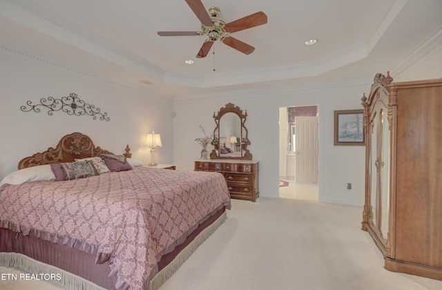 bedroom with ensuite bath, ceiling fan, a raised ceiling, crown molding, and light carpet