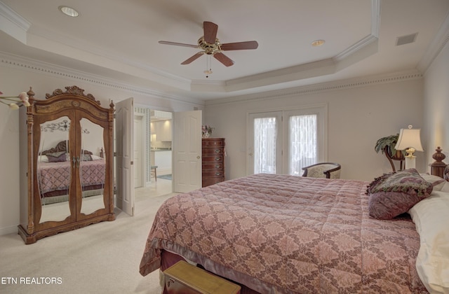 carpeted bedroom featuring a tray ceiling, ceiling fan, and crown molding