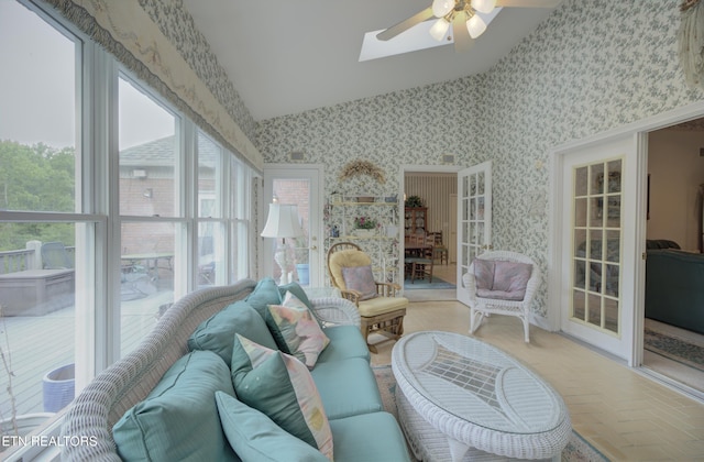 sunroom with ceiling fan, a healthy amount of sunlight, and vaulted ceiling with skylight